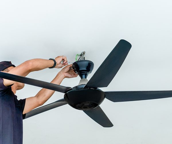 A man installing a ceiling fan. Home improvement, professional work, and technical skill concept.